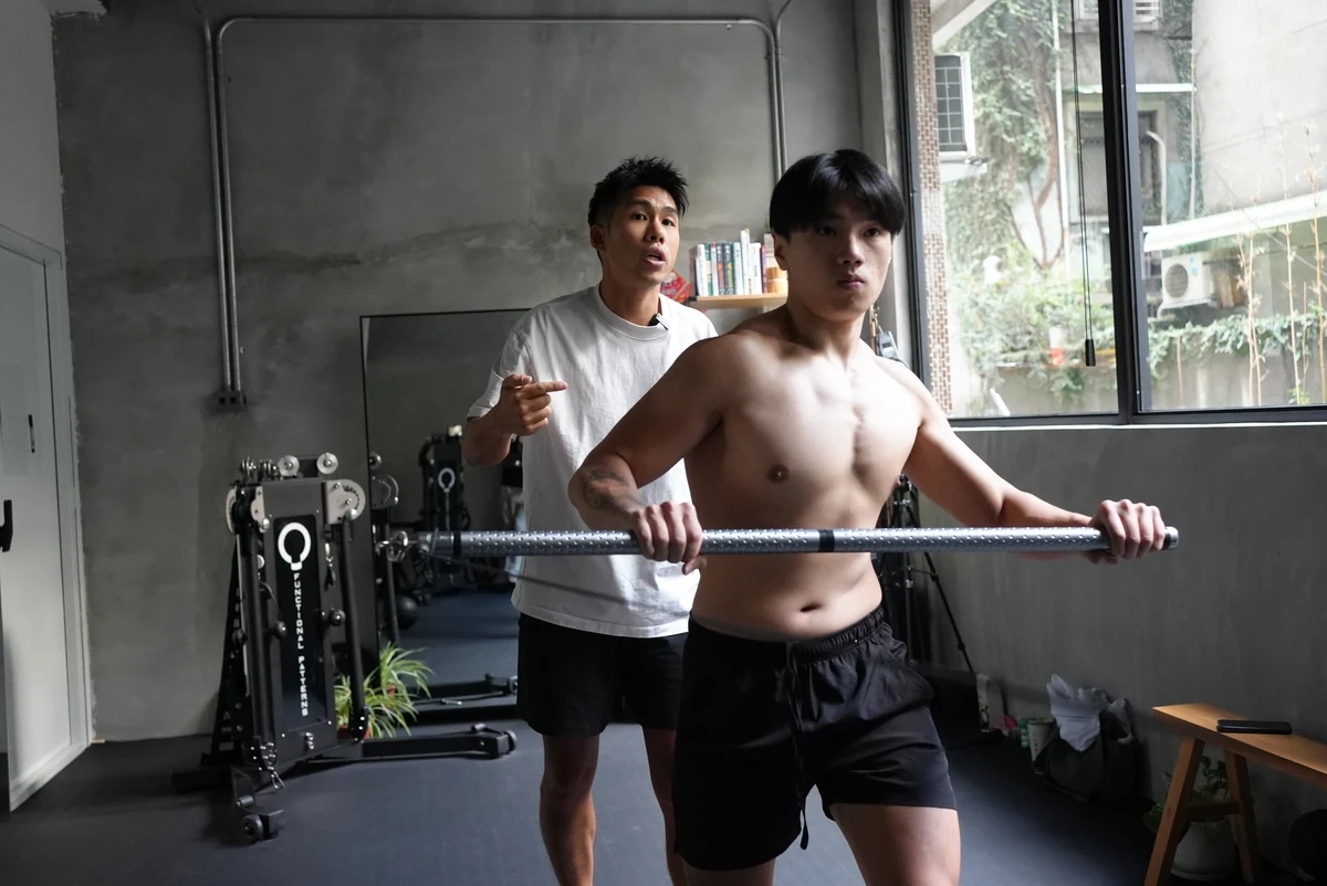 第一力學工作室一角，Taka 在學員身後指導橫桿動作